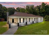 Charming single-story home featuring a welcoming front porch, brick facade, and beautiful landscaping at 509 8Th Avenue Ext, Cramerton, NC 28032