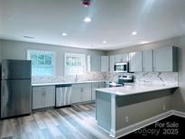 Bright, updated kitchen featuring stainless steel appliances and stone countertops with bar seating at 509 8Th Avenue Ext, Cramerton, NC 28032
