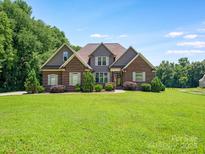 Charming brick home with a well-manicured lawn and landscaping provides excellent curb appeal at 1011 Duntov Dr, Monroe, NC 28110