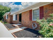 Charming brick home featuring a well-maintained front yard with red shutters and tidy landscaping at 1140 Mckinnon Dr, Rock Hill, SC 29732
