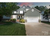 Charming two-story home featuring stone accents, a well-manicured lawn, and a two-car garage at 1677 Shetland Ln, Rock Hill, SC 29730
