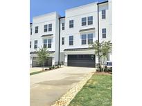 New construction townhome featuring a large driveway, garage, modern siding, and a manicured lawn at 2137 Barrowcliffe Dr # 49, Concord, NC 28027