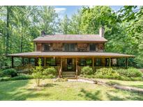 Charming two-story home with a large, inviting front porch and mature landscaping at 2615 Highway 557 None, Clover, SC 29710