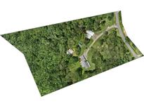 An aerial view of a secluded home and surrounding property with mature trees and long driveway at 265 River Run Rd, Statesville, NC 28625