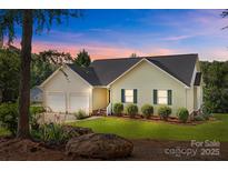 Charming single Gathering home featuring a well-manicured lawn and a two car garage at dusk at 2906 Plantation Way, Albemarle, NC 28001