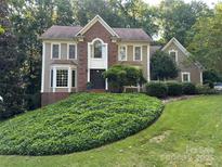 Charming two-story home featuring a brick facade, bay window, and a well-maintained, lush front yard at 5024 Ardenwoods Dr, Charlotte, NC 28215