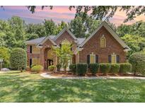 Charming brick home featuring manicured landscaping, a walkway and a two-story entryway at 6612 Saunton Ct, Charlotte, NC 28277