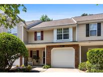 Charming townhouse with brick accents, a one-car garage, and well-maintained landscaping at 9977 Reindeer Way Ln, Charlotte, NC 28216