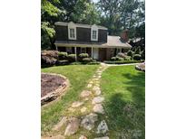 Charming two-story home with landscaped yard and a stone walkway leading to the front door at 101 Treeline Dr, Belmont, NC 28012