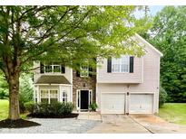 Charming two-story home featuring a two-car garage, stone accents, and a well-manicured lawn at 4205 Springhaven Dr, Charlotte, NC 28269