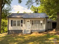 Charming home featuring a quaint porch, complemented by fresh, neutral siding and a durable metal roof at 608 E 11Th St, Newton, NC 28658