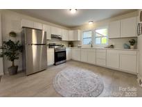 Bright kitchen features modern appliances, white cabinets, light countertops and tile flooring at 608 E 11Th St, Newton, NC 28658