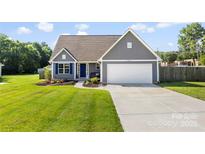 Charming home with blue shutters, a well-maintained lawn, and a two-car garage at 6401 Morehead Rd, Harrisburg, NC 28075