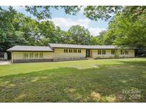 Charming ranch-style home with large front lawn and mature trees providing shade at 7107 Cedarfield Rd, Charlotte, NC 28227