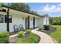 Charming home featuring a cozy front porch with seating and beautifully landscaped front yard at 7109 Forney Hill Rd, Denver, NC 28037