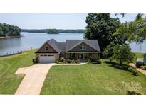 Charming waterfront home with lush lawn, mature trees, and a tranquil lake view at 735 Pebble Pt, Salisbury, NC 28146