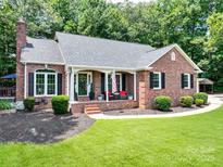 Charming single-story brick home featuring a welcoming front porch, manicured lawn, and classic black shutters at 132 General Pemberton St, Stanley, NC 28164