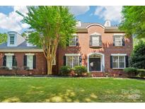 Classic brick home with a well-manicured lawn and mature tree in a desirable neighborhood at 15620 Glen Miro Dr, Huntersville, NC 28078