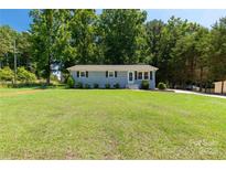 Charming one-story home with light blue brick, black shutters, and a large lawn at 203 Nottingham Dr, York, SC 29745