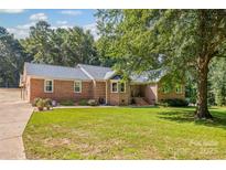 Charming brick home featuring lush green lawn and mature trees, perfect for outdoor enjoyment at 229 Campsite Rd, Rock Hill, SC 29732