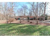 Charming ranch style home with brick accents and a long, private driveway surrounded by mature trees at 251 Gleneagles E Rd, Statesville, NC 28625