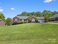 Charming brick home with a well-manicured lawn and mature landscaping, perfect for outdoor enjoyment at 3906 Brickfield St, Hickory, NC 28602