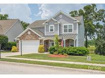 Charming two-story home features a manicured lawn and a stone and gray shingle facade at 4090 Sunset Dr, Rock Hill, SC 29732