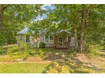 Charming single-story home featuring a metal roof and inviting front porch, nestled amongst mature shade trees at 4699 Cherrystone Rd, Lancaster, SC 29720