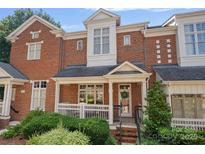Charming brick townhouse with a covered front porch and well-maintained landscaping at 4708 S Hill View Dr, Charlotte, NC 28210