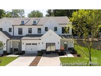 Charming, new construction townhome featuring a white exterior, garage and well-manicured lawn at 622 Station St # 48, Clover, SC 29710