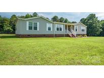 Charming single-story home featuring a welcoming front porch, gray siding, and a well-maintained lawn at 6785 Knotty Wood Ln, Vale, NC 28168