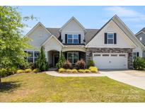 Charming two-story home features a manicured front yard, stone accents, and a welcoming two-car garage at 6907 Hunts Mesa Dr, Fort Mill, SC 29707