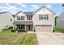 Charming two-story home featuring a well-manicured lawn and inviting front porch at 1216 Catawba Run, Lowell, NC 28098