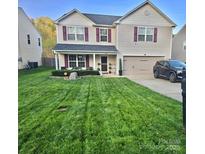Charming two-story home with a well-manicured lawn, beautiful landscaping, and a two-car garage at 1216 Catawba Run, Lowell, NC 28098