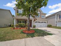 Charming two-story home with a well-manicured lawn and a two car garage and lovely stone accents at 1307 Farm Branch Sw Dr, Concord, NC 28027