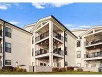 Beautiful three-story condo with multiple balconies and classic white siding on a manicured lawn at 17811 Half Moon Ln # E, Cornelius, NC 28031