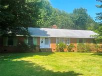 Charming brick home featuring a well-manicured lawn and mature trees at 1834 Sharonwood Ln, Rock Hill, SC 29732