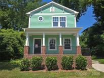 Charming two-story home features a welcoming front porch and vibrant green siding at 405 S South St, Gastonia, NC 28052