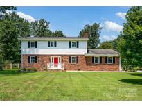 Charming two-story home with a red brick facade and a bright red front door at 4121 Dover St, Claremont, NC 28610