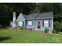 Charming blue single-Gathering home with a red door, black shutters, and a well-manicured lawn at 792 W Nc Hwy 150 St, Lincolnton, NC 28092