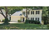 Charming two-story home with a well-maintained lawn, attached two car garage, and mature trees at 8510 Glade Ct, Huntersville, NC 28078