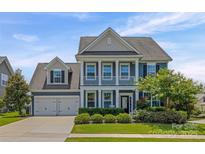 Charming two-story home with a two car garage, inviting front porch, and manicured landscaping at 958 Skywater Dr, Fort Mill, SC 29715