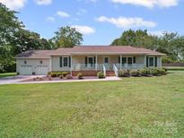 Charming single-story home with a welcoming front porch, landscaped yard, and attached two-car garage at 1302 Hawthorne Rd, Lancaster, SC 29720