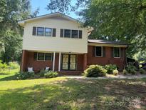 Charming two-story home with a manicured lawn and mature trees offering great curb appeal at 1909 Normandy Rd, Kannapolis, NC 28081