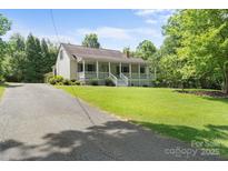 Inviting home featuring a charming front porch, well-manicured lawn, and a long driveway at 1920 E Nc Hwy 24/27 None, Biscoe, NC 27209