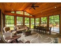 Inviting sunroom features a wood ceiling, large windows, and comfortable seating for relaxation and dining at 2156 Wedgewood Dr, Matthews, NC 28104