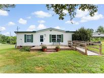 Charming single story home featuring a landscaped yard, front porch, and wheelchair ramp access at 223 Green Meadows Dr, Kings Mountain, NC 28086