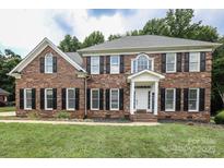 Classic brick two-story home featuring black shutters and a well-manicured lawn at 3015 Rochester Ct, Monroe, NC 28110