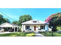 Charming single-story home with a metal roof, covered porch, carport and mature trees at 402 Madison St, Lincolnton, NC 28092