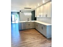 Modern kitchen with stainless steel appliances, white cabinets, and hardwood flooring at 5234 Bellflower Ln, Charlotte, NC 28227